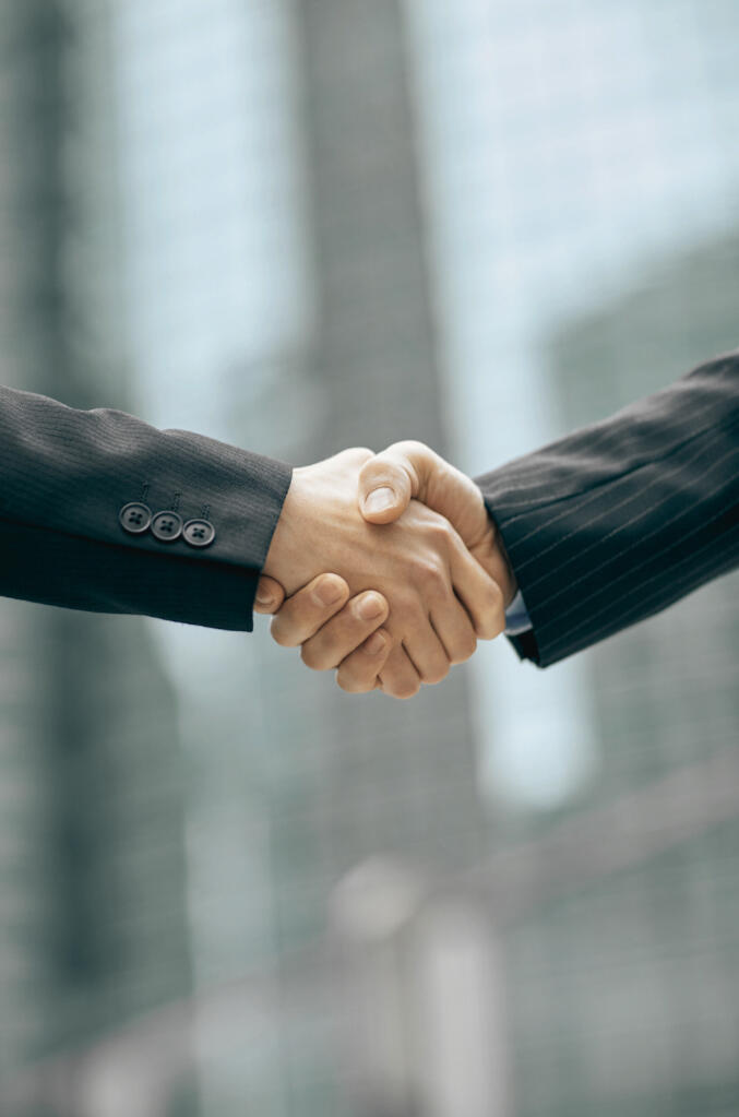 Two people shake hands Two people shake hands after making a great deal for both!